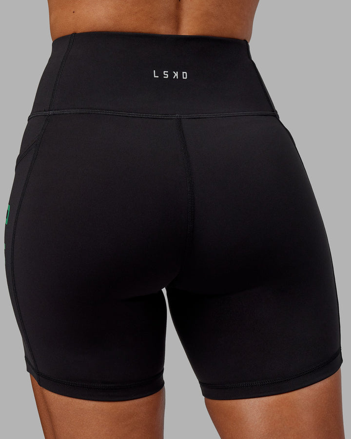 Woman wearing Rep Mid-Length Shorts - Black-Impact Green
