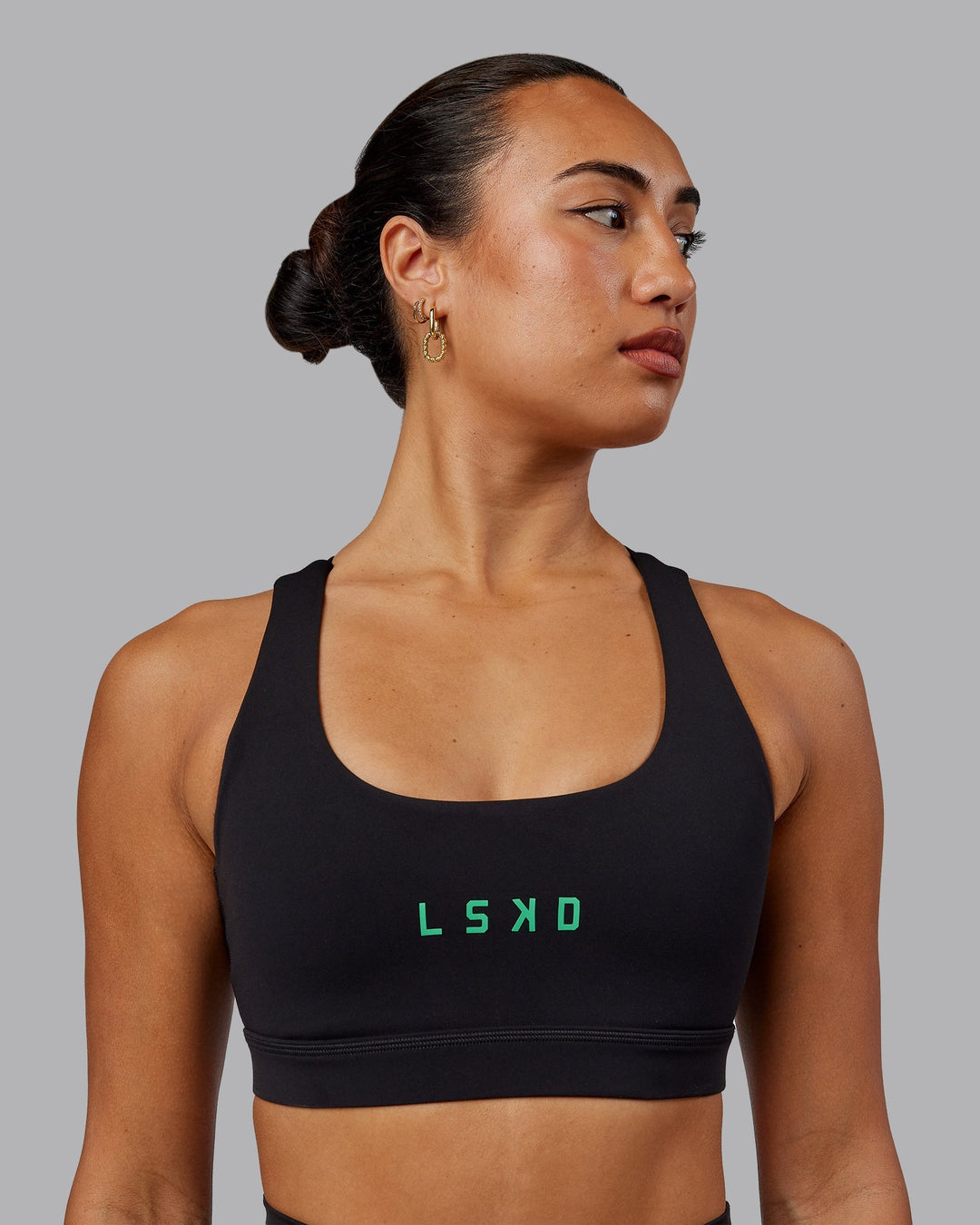 Woman wearing Rep Sports Bra - Black-Impact Green