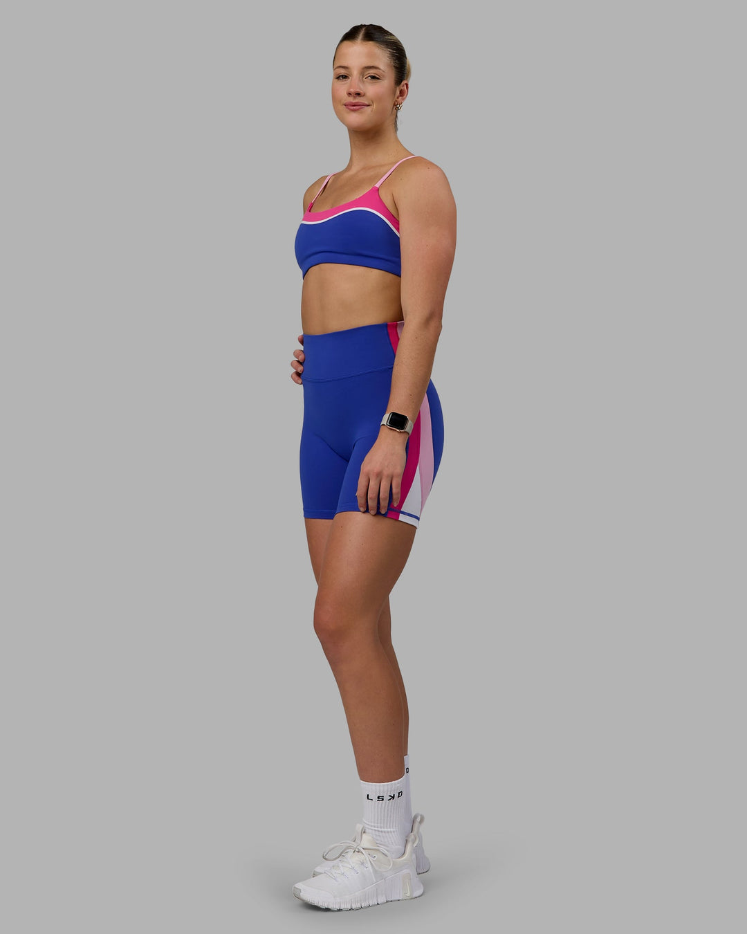 Woman wearing Revitalise Mid Short Tights - Power Cobalt-Fuchsia Pink