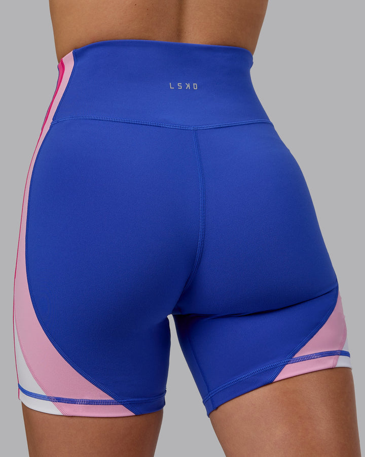 Woman wearing Revitalise Mid Short Tights - Power Cobalt-Fuchsia Pink
