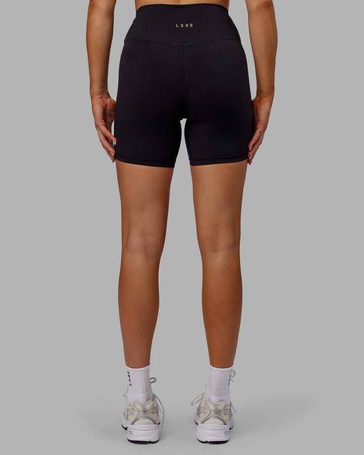 Woman wearing Sara Strike Cross Over Waist Mid-Length Shorts - Black
