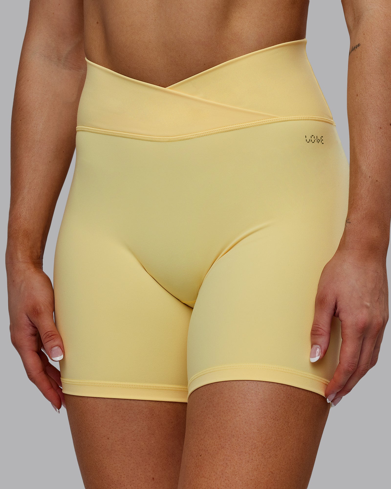 Woman wearing Sara Strike Ultra High-Rise Cross Over Waist 6" Short - Sunflower