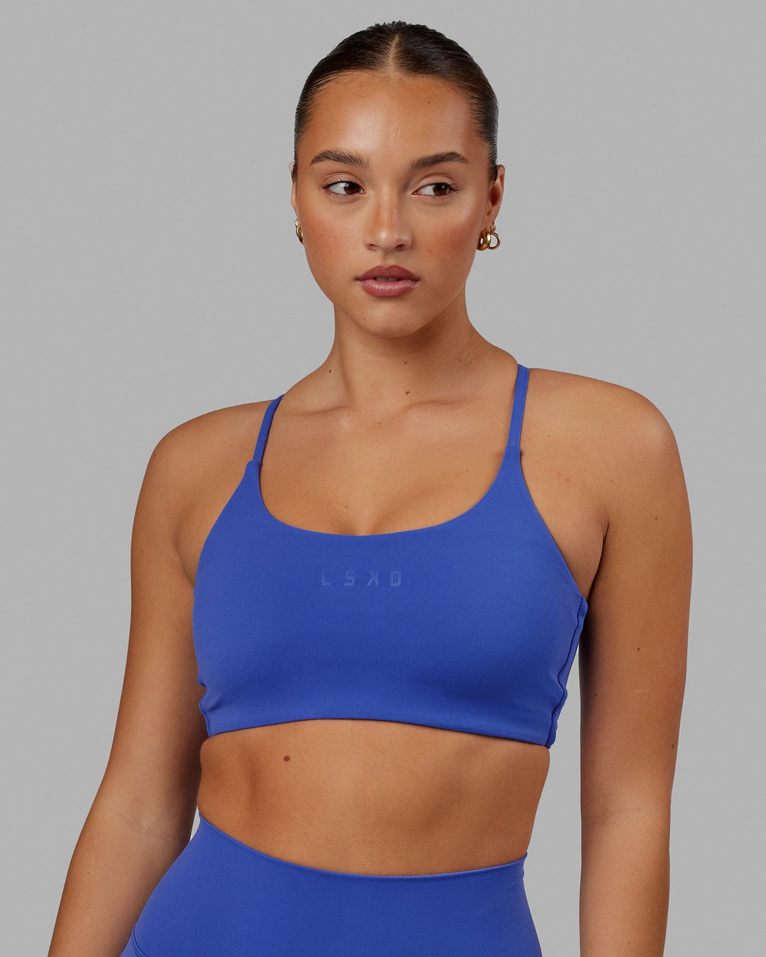 Woman wearing Twist Sports Bra - Power Cobalt