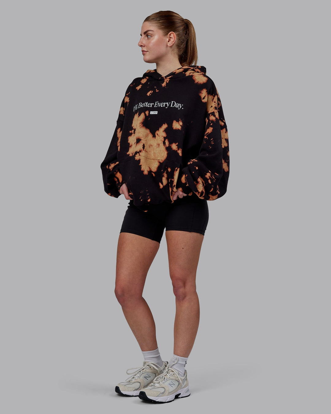 Woman wearing Unisex 1% Better Hoodie Oversize - Black-Bleach-Tie Dye