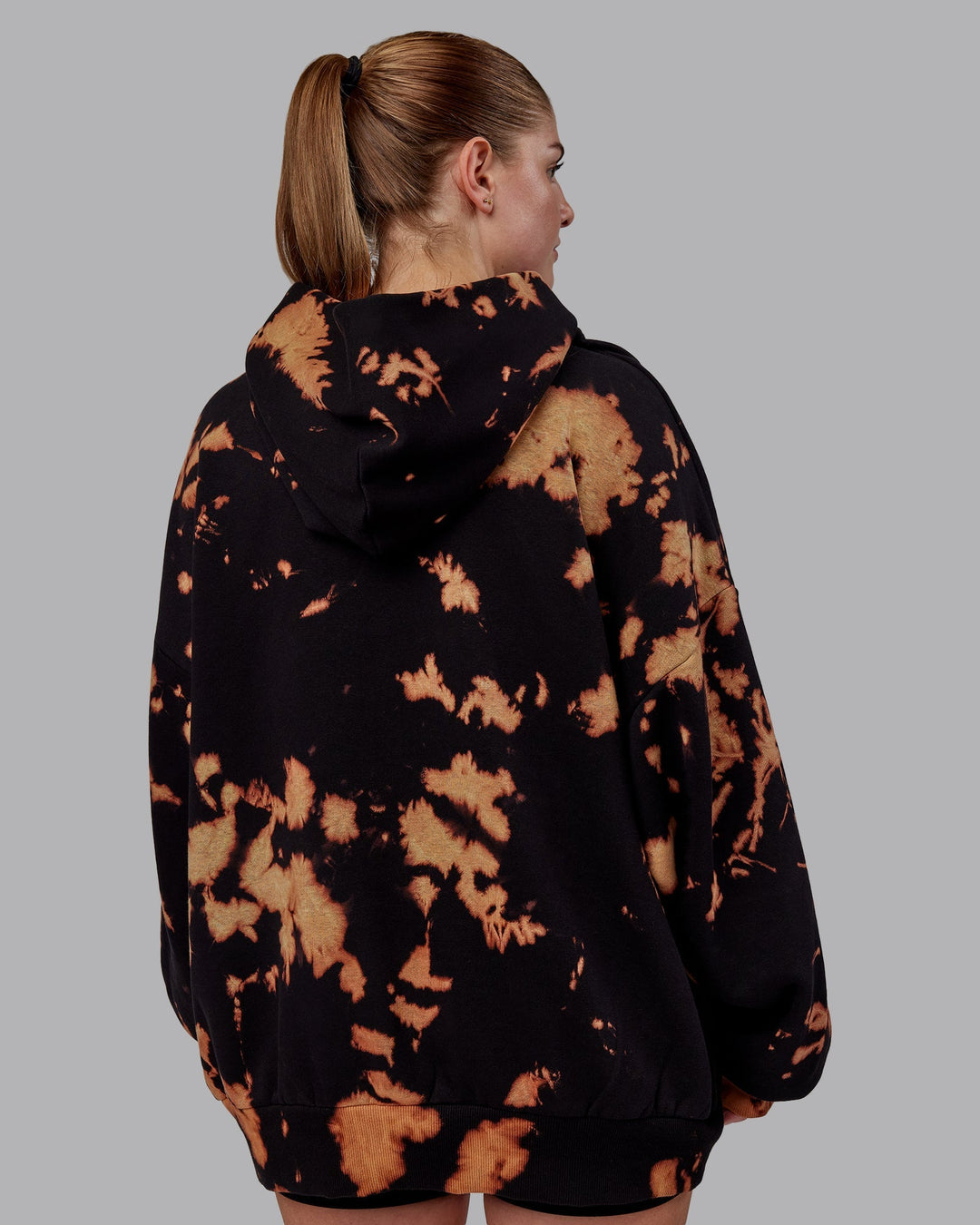 Woman wearing Unisex 1% Better Hoodie Oversize - Black-Bleach-Tie Dye