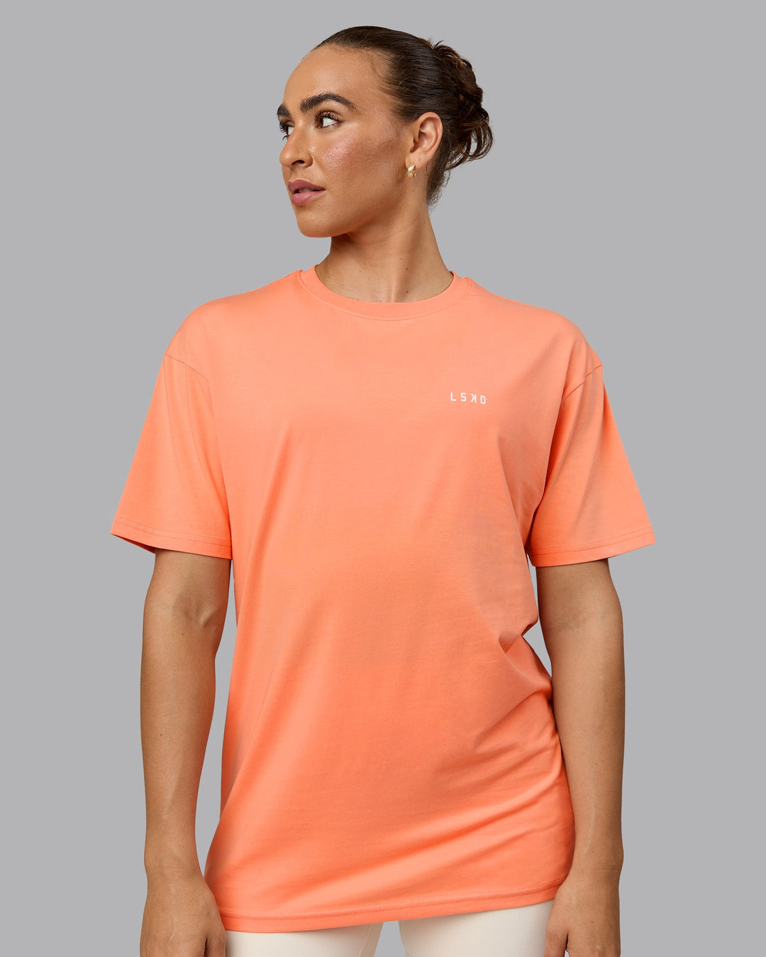 Woman wearing Unisex 1% Better Value Series FLXCotton Tee Oversize - Mellow Peach-White