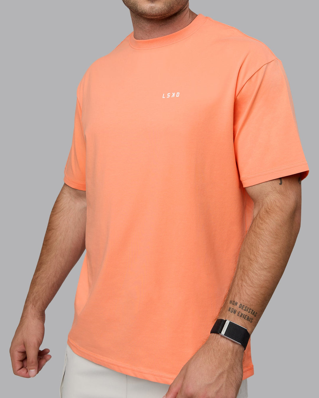 Man wearing Unisex 1% Better Value Series FLXCotton Tee Oversize - Mellow Peach-White