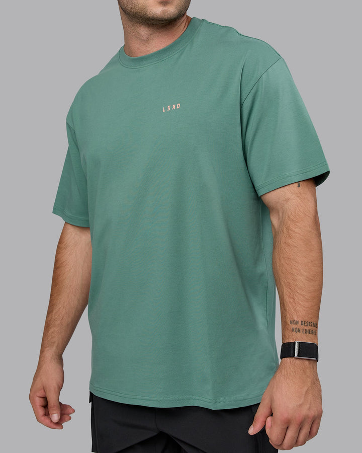 Man wearing Unisex 1% Better Value Series FLXCotton Tee Oversize - Sagebrush-Mellow Peach
