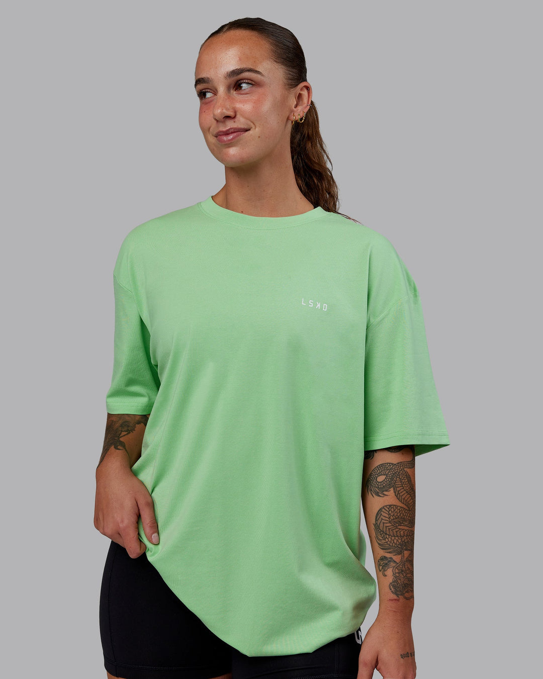 Woman wearing Unisex 1% Better Value Series FLXCotton Tee Oversize - Surreal Green-White