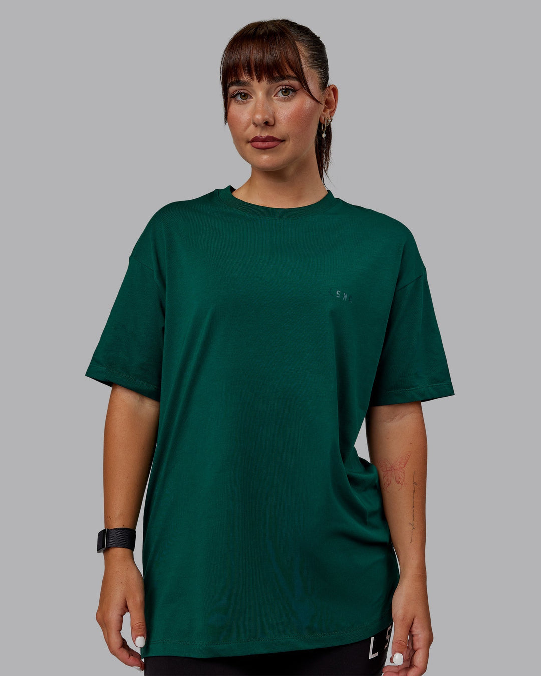 Woman wearing Unisex Deluxe PimaFLX Tee Oversize - Deep Emerald