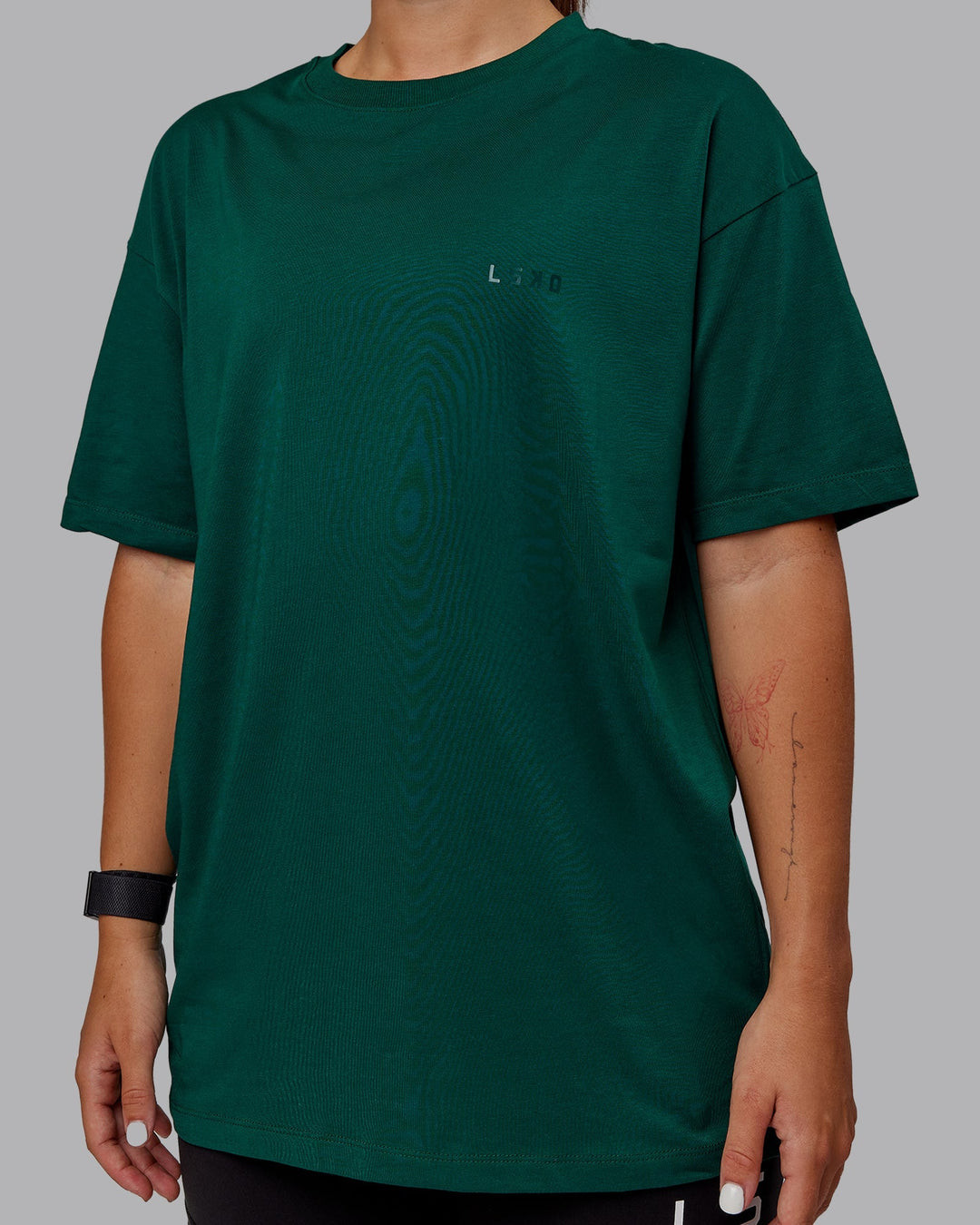 Woman wearing Unisex Deluxe PimaFLX Tee Oversize - Deep Emerald