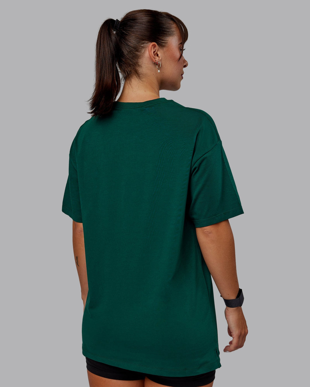 Woman wearing Unisex Deluxe PimaFLX Tee Oversize - Deep Emerald