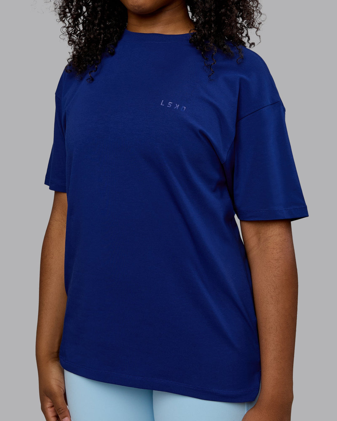 Woman wearing Unisex Deluxe PimaFLX Tee Oversize - Midnight Blue