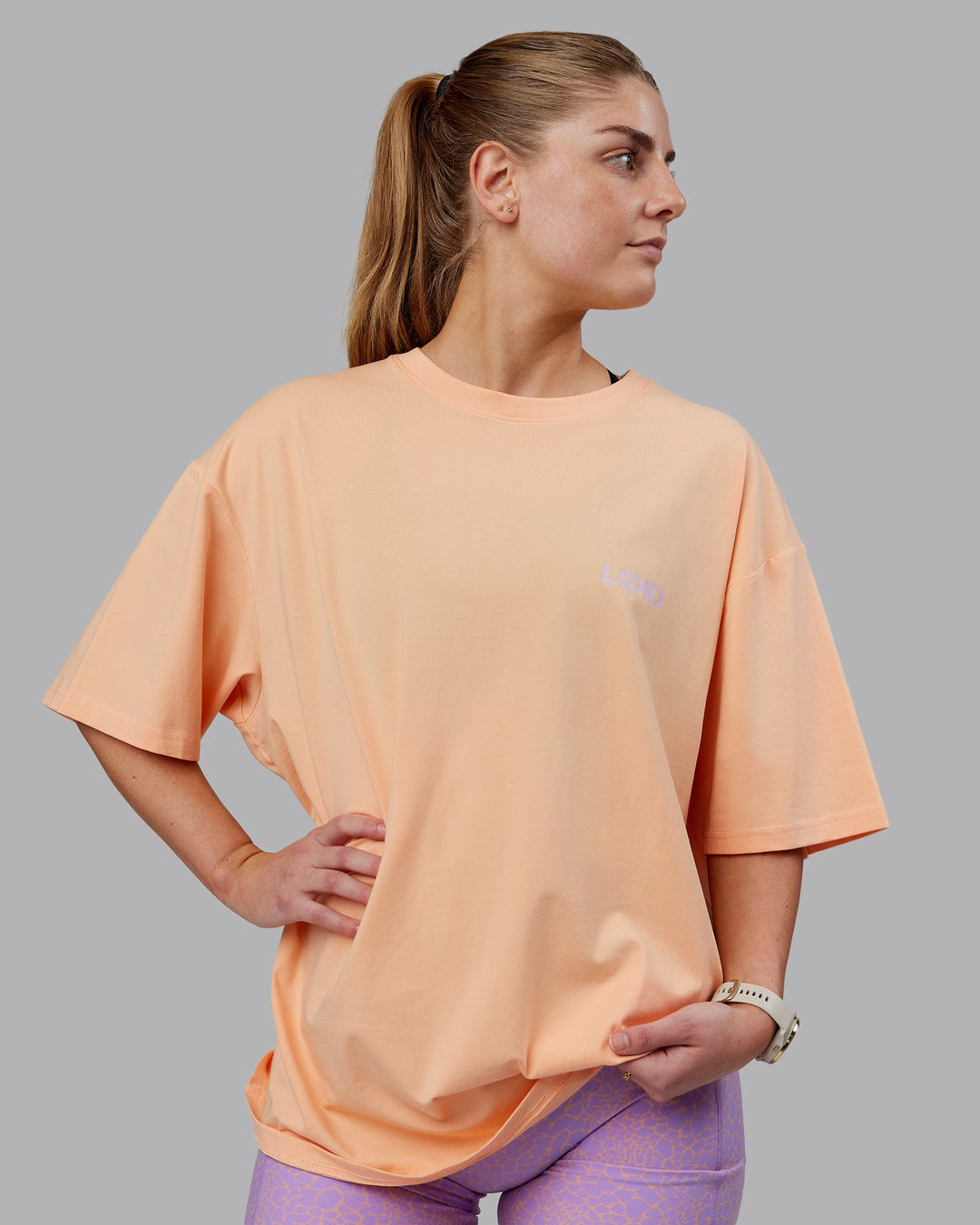 Woman wearing Unisex E.T.J FLXCotton Tee Oversize - Peach Fuzz-Purple