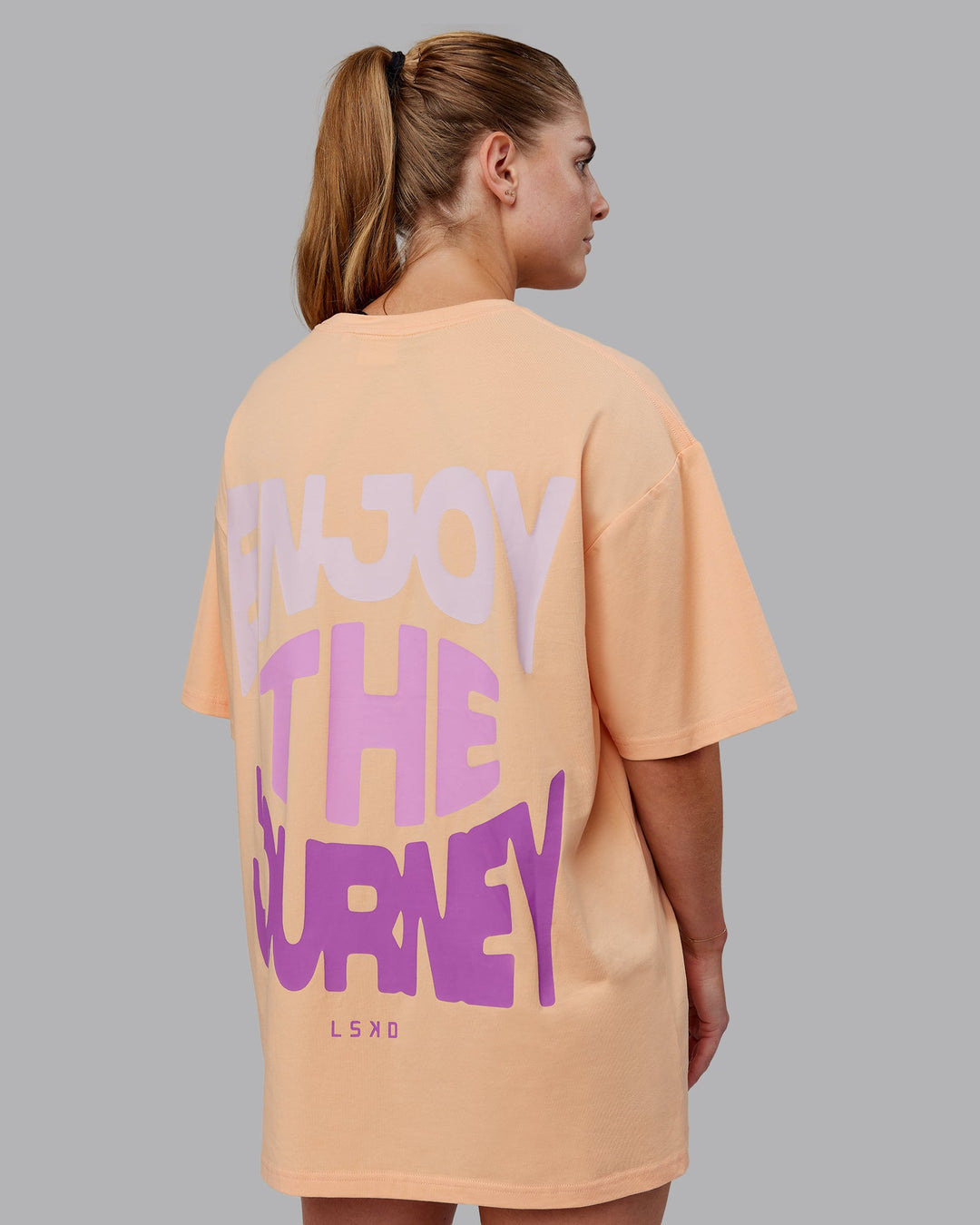 Woman wearing Unisex E.T.J FLXCotton Tee Oversize - Peach Fuzz-Purple