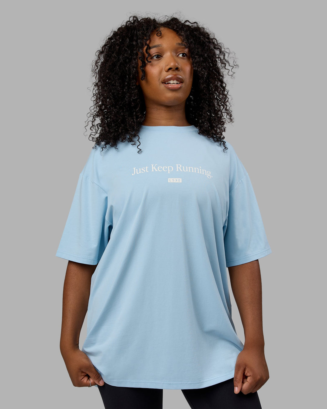 Woman wearing Unisex Just Keep Running FLXCotton Tee Oversize - Glacial Blue-Off White