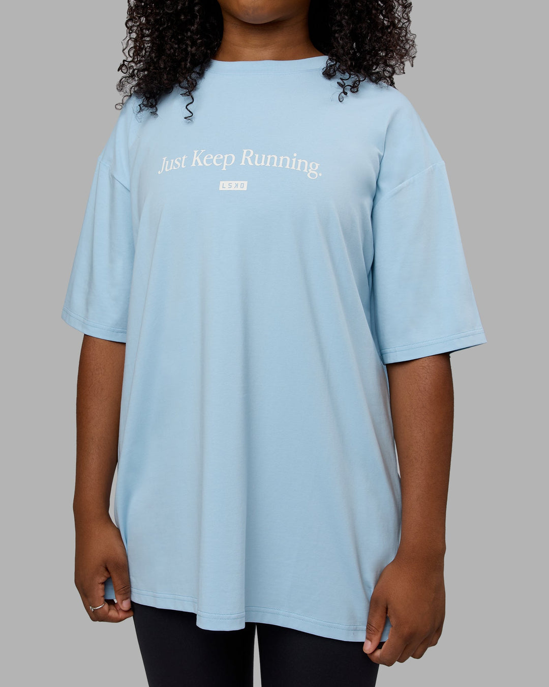 Woman wearing Unisex Just Keep Running FLXCotton Tee Oversize - Glacial Blue-Off White