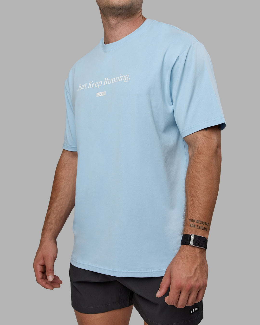 Man wearing Unisex Just Keep Running FLXCotton Tee Oversize - Glacial Blue-Off White