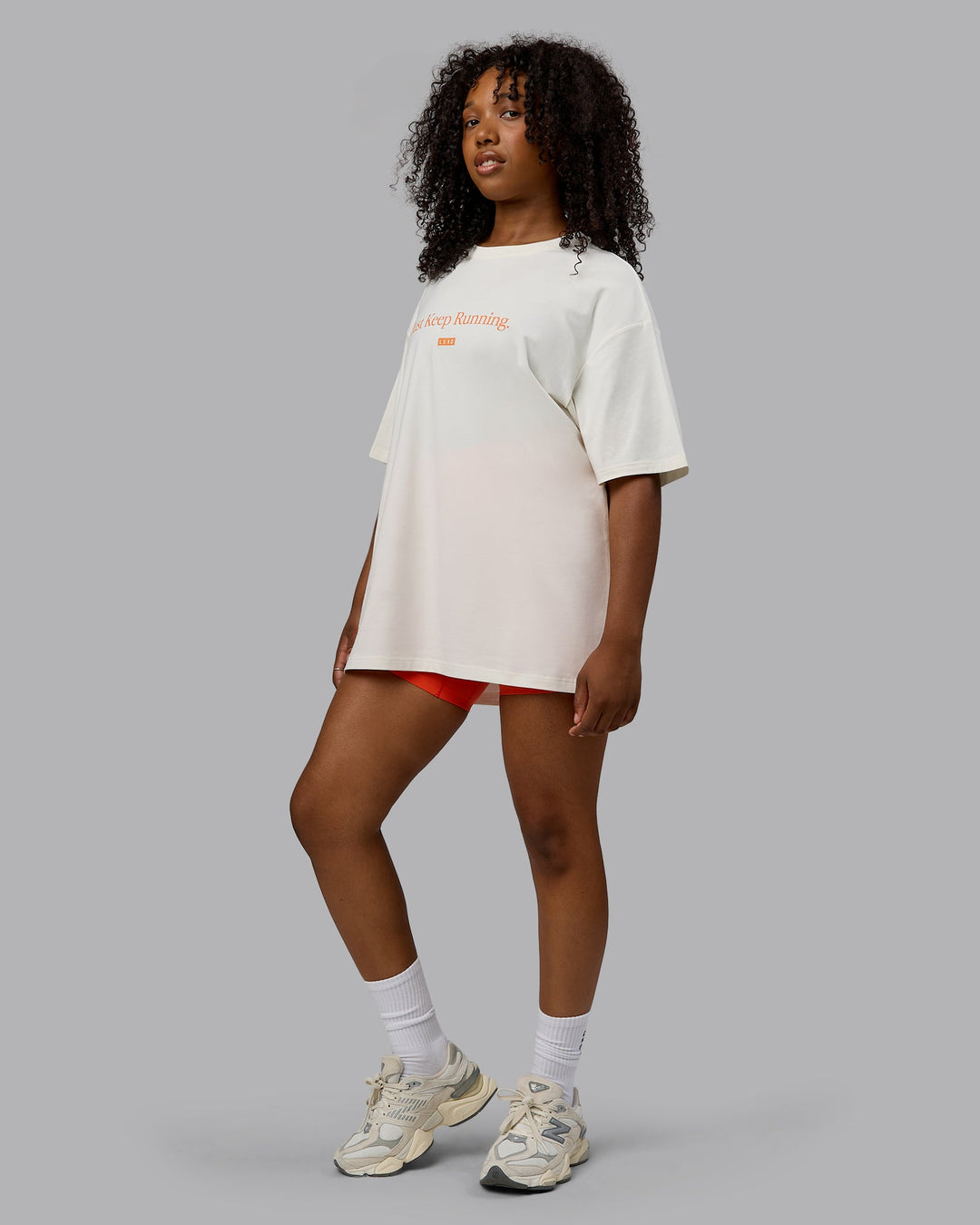 Woman wearing Unisex Just Keep Running FLXCotton Tee Oversize - Off White-Vibrant Orange