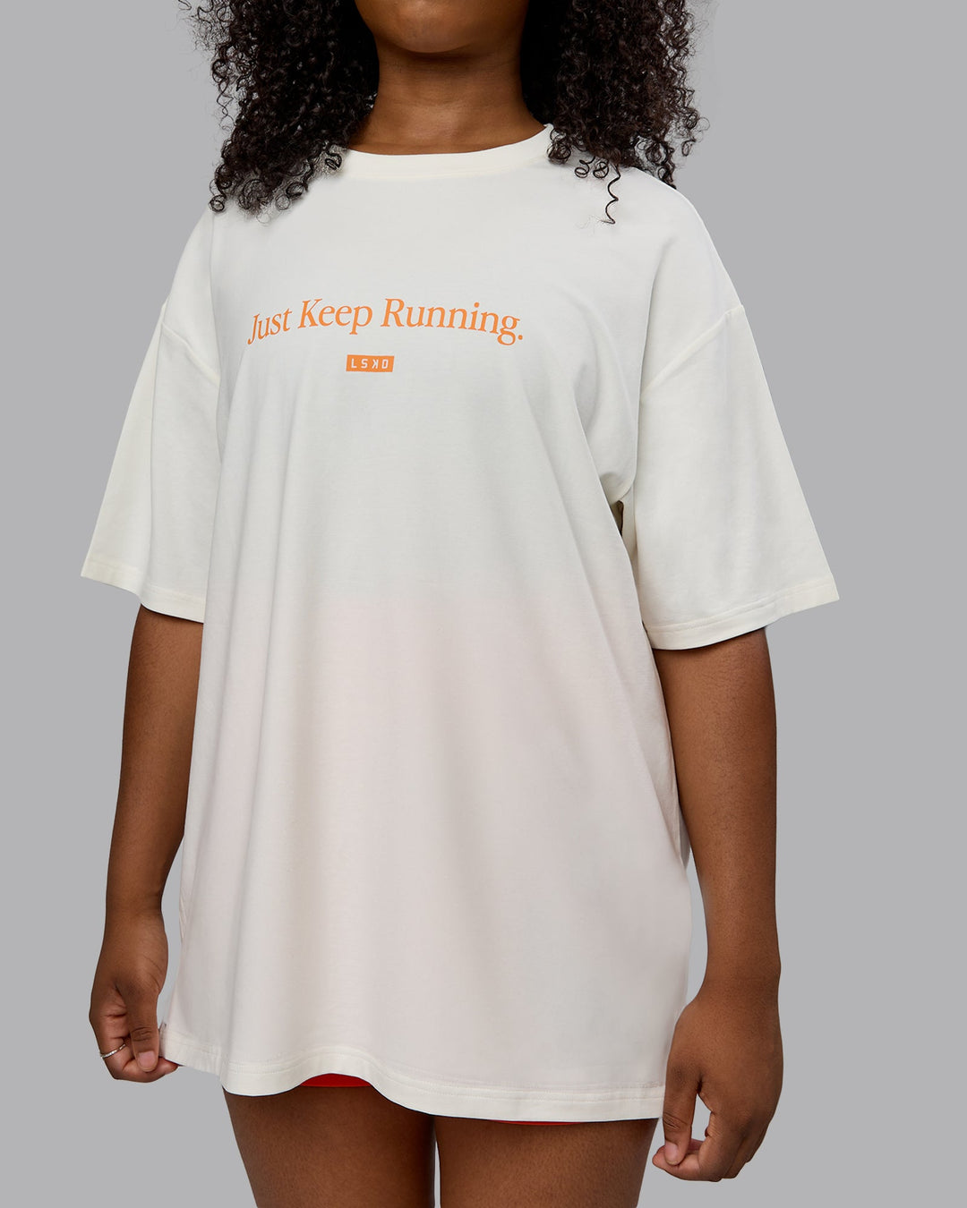 Woman wearing Unisex Just Keep Running FLXCotton Tee Oversize - Off White-Vibrant Orange