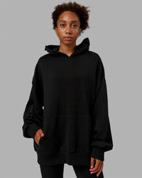 Woman wearing Unisex MVP Hoodie Oversize - Black