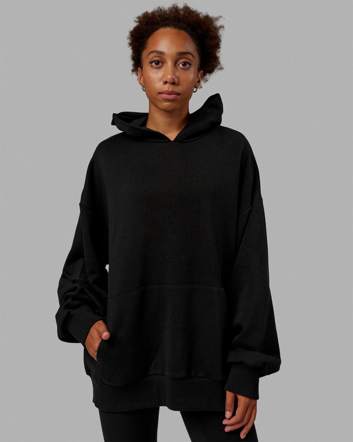 Woman wearing Unisex MVP Hoodie Oversize - Black