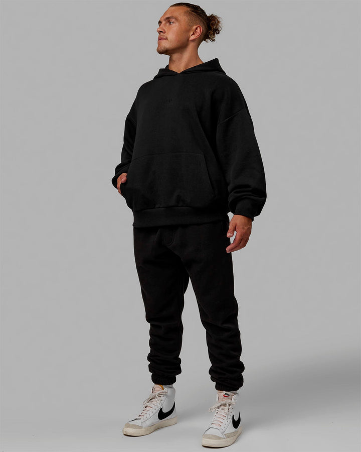 Man wearing Unisex MVP Hoodie Oversize - Black