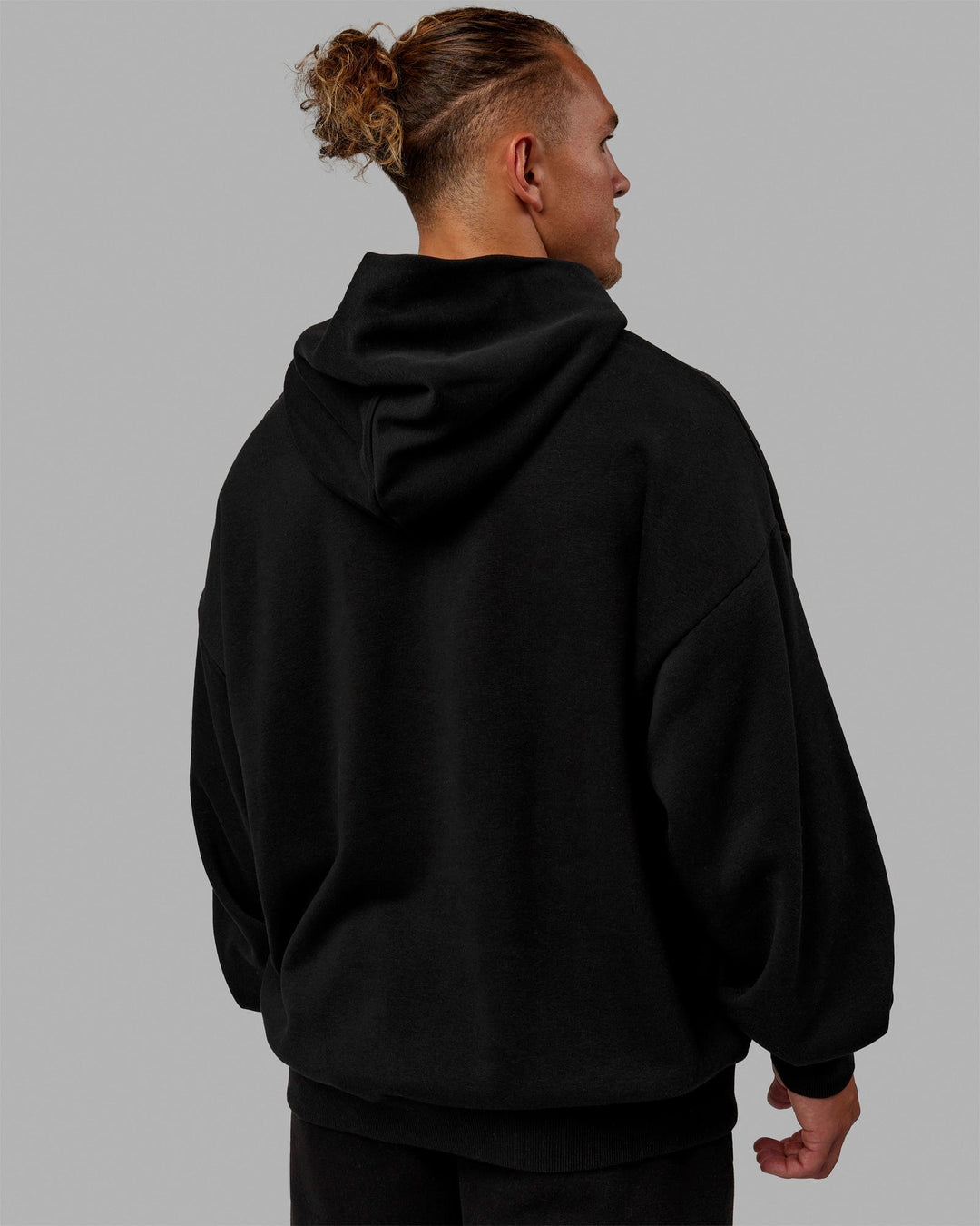 Man wearing Unisex MVP Hoodie Oversize - Black