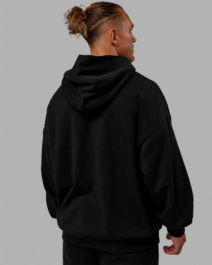 Man wearing Unisex MVP Hoodie Oversize - Black
