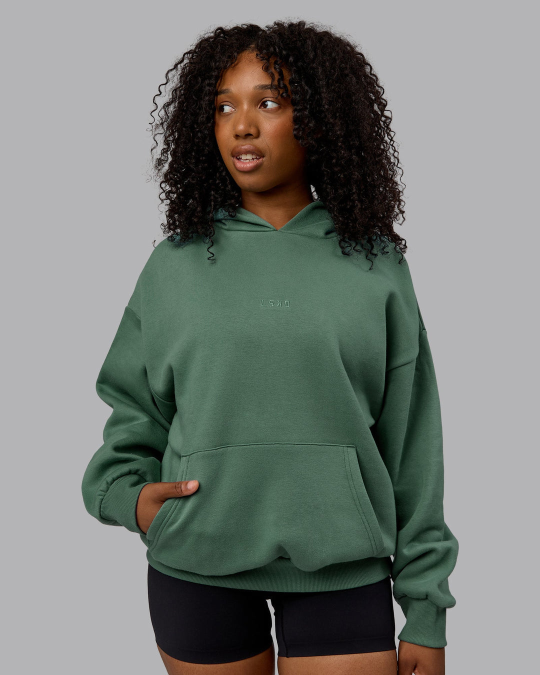 WOman wearing Unisex MVP Hoodie Oversize - Sage Brush