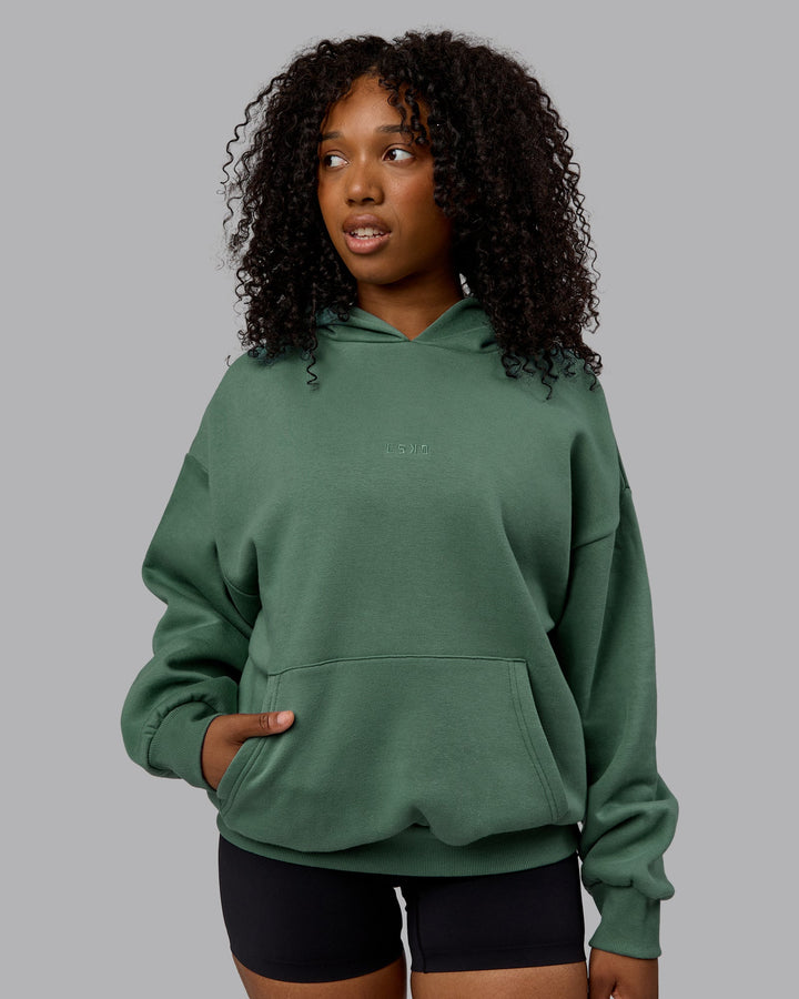 WOman wearing Unisex MVP Hoodie Oversize - Sage Brush
