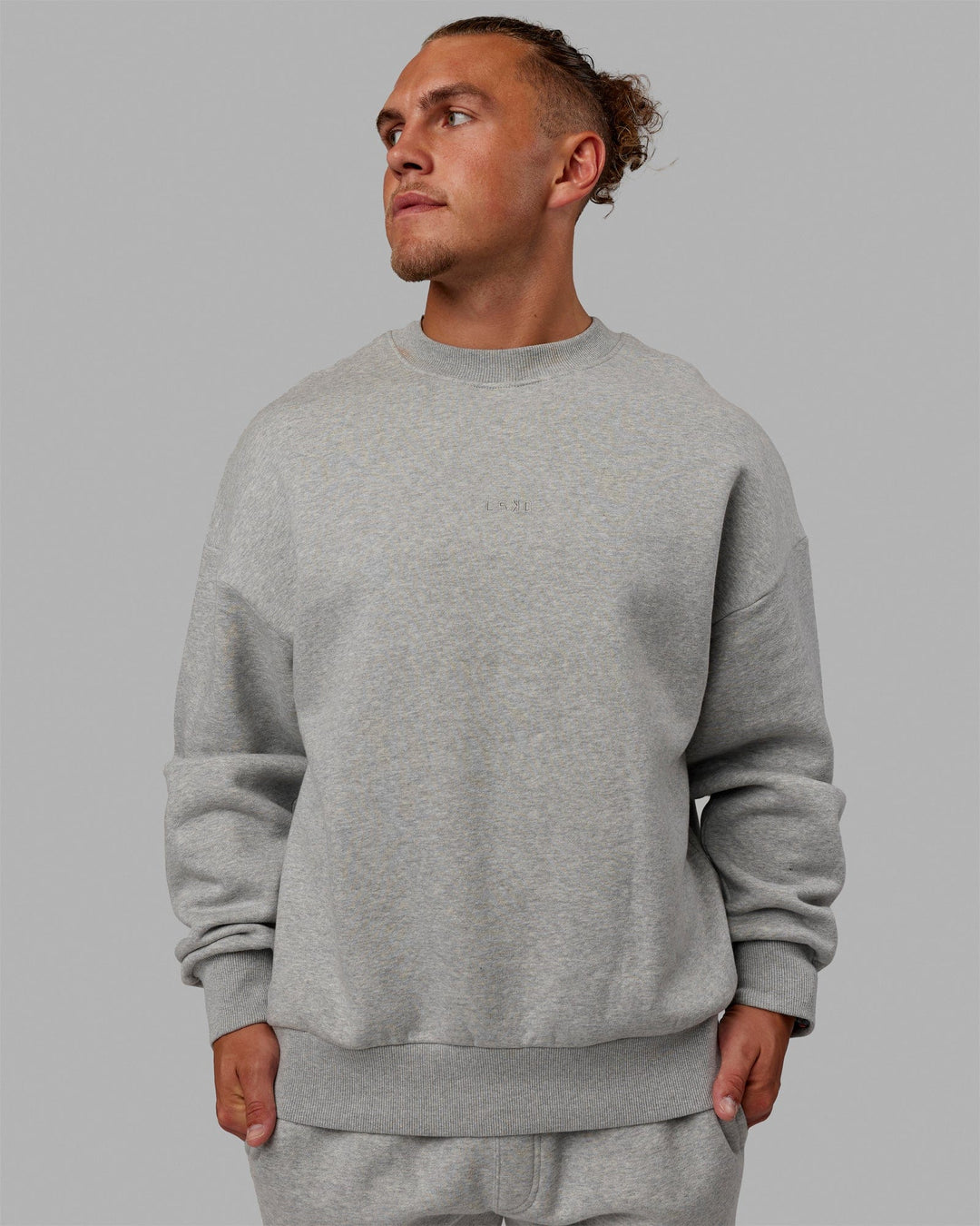 Man wearing Unisex MVP Sweater Oversize - Light Grey Marl