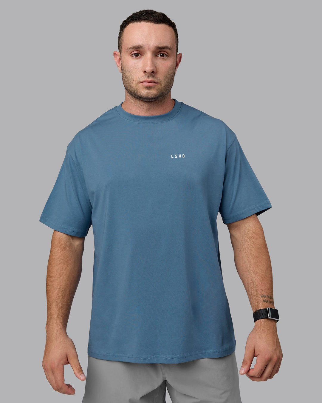 Man wearing Unisex Move Fast Value Series FLXCotton Tee Oversize - Elemental Blue-Off White