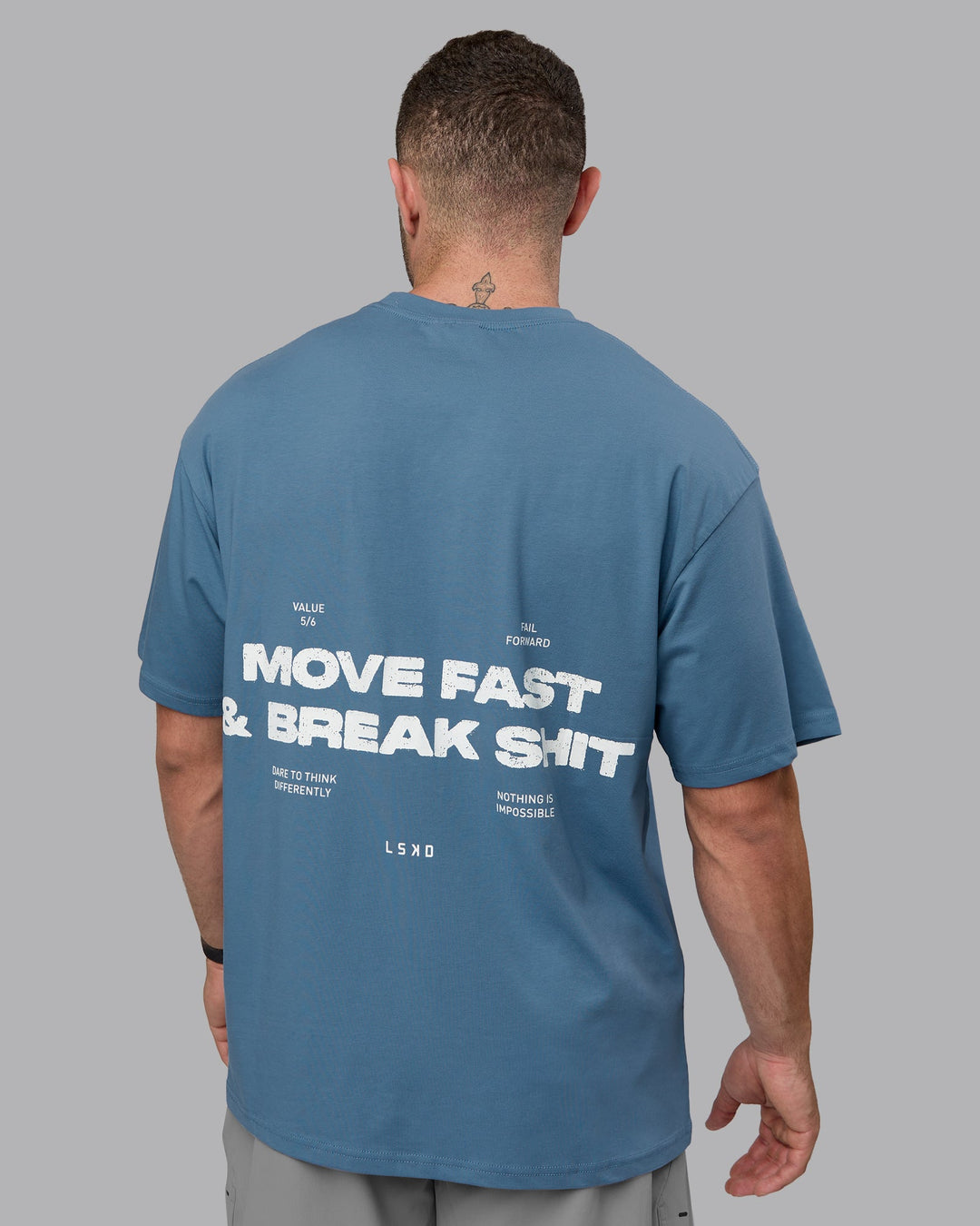 Man wearing Unisex Move Fast Value Series FLXCotton Tee Oversize - Elemental Blue-Off White