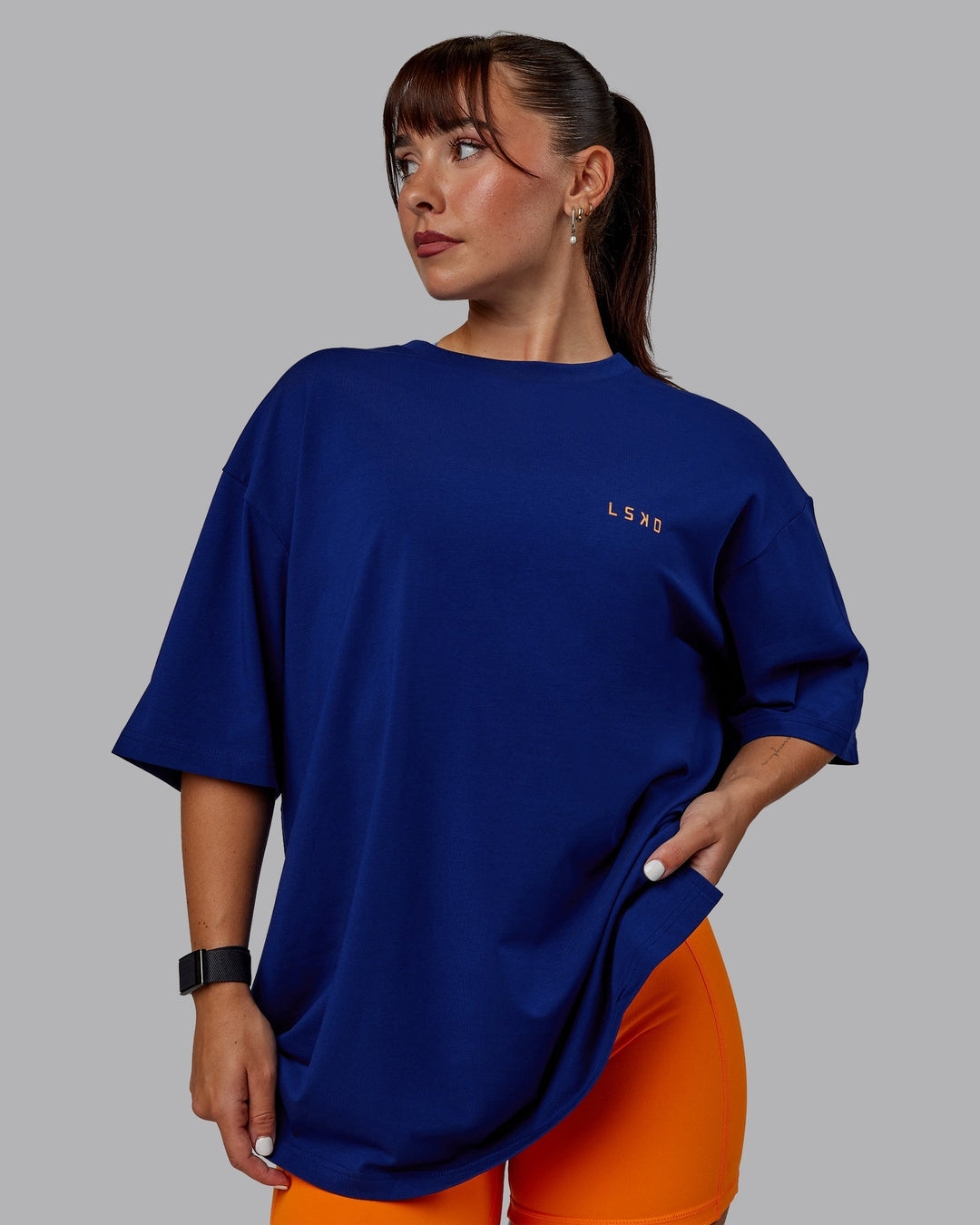 Woman wearing Unisex Strike Through FLXCotton Tee Oversize - Midnight Blue-Vibrant Orange