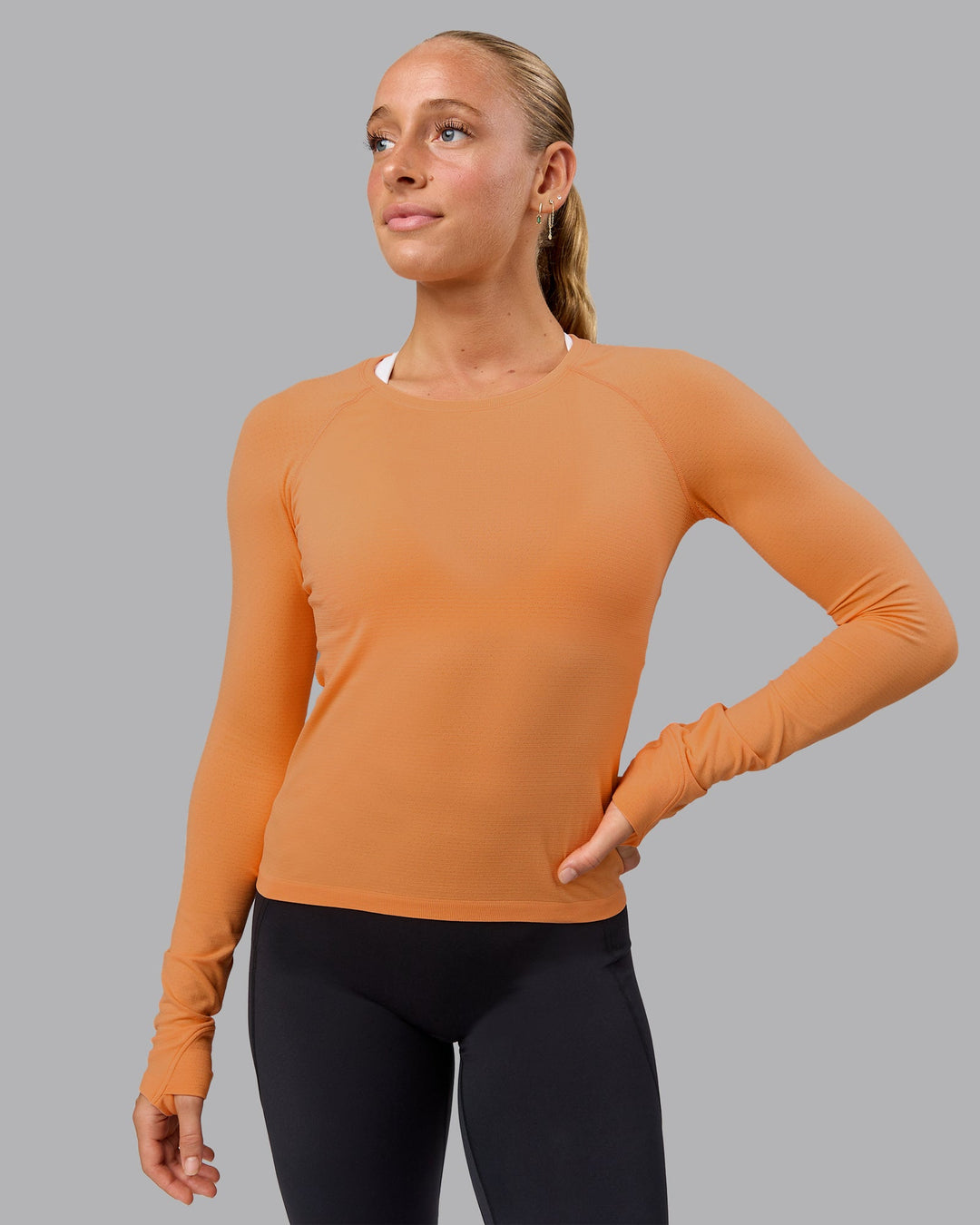 Woman wearing AeroFLX+ Seamless Long Sleeve Tee - Cantaloupe