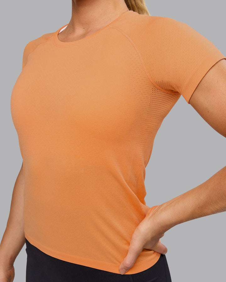 Woman wearing AeroFLX+ Seamless Tee - Cantaloupe
