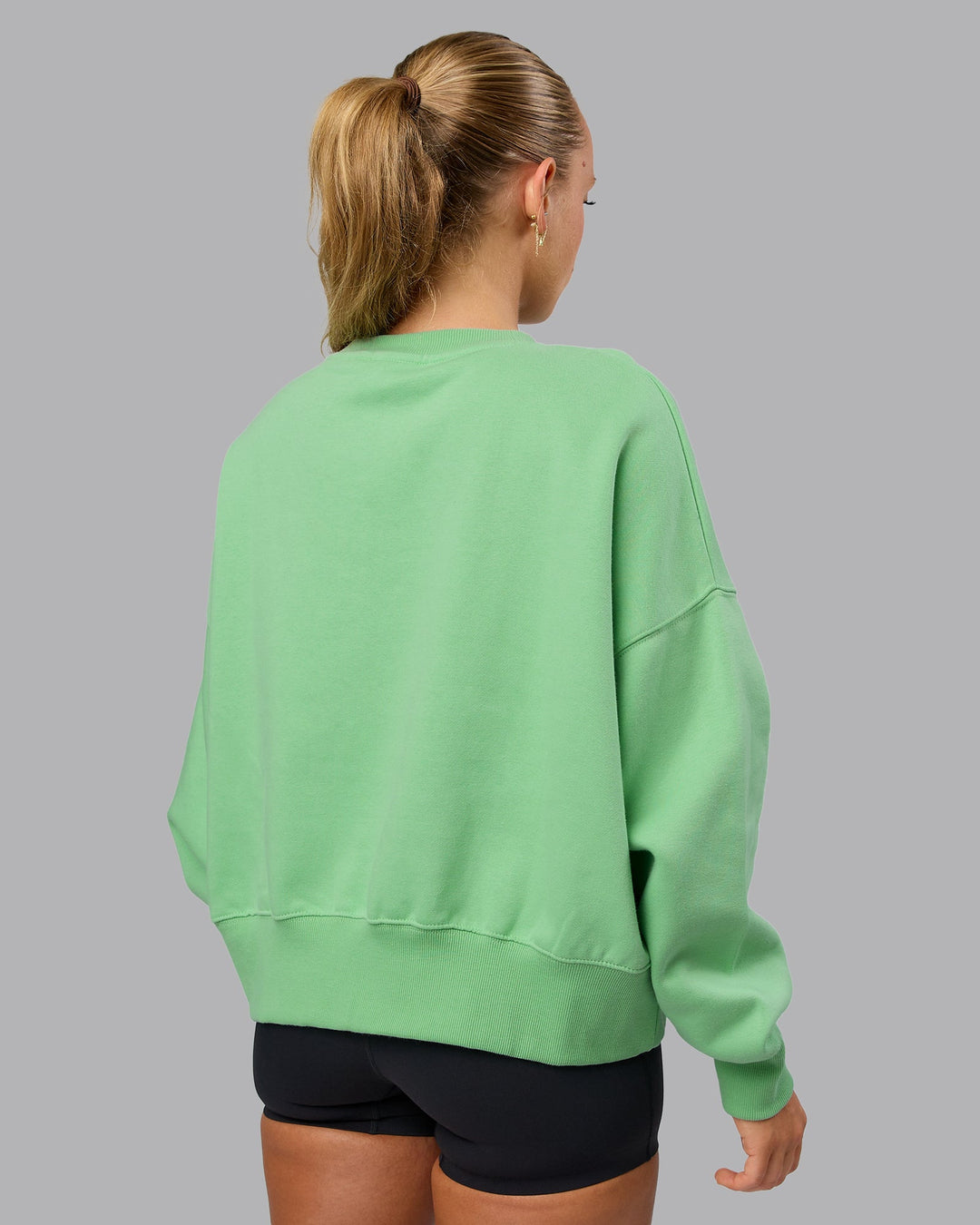 Woman wearing MVP Oversized Sweater - Surreal Green