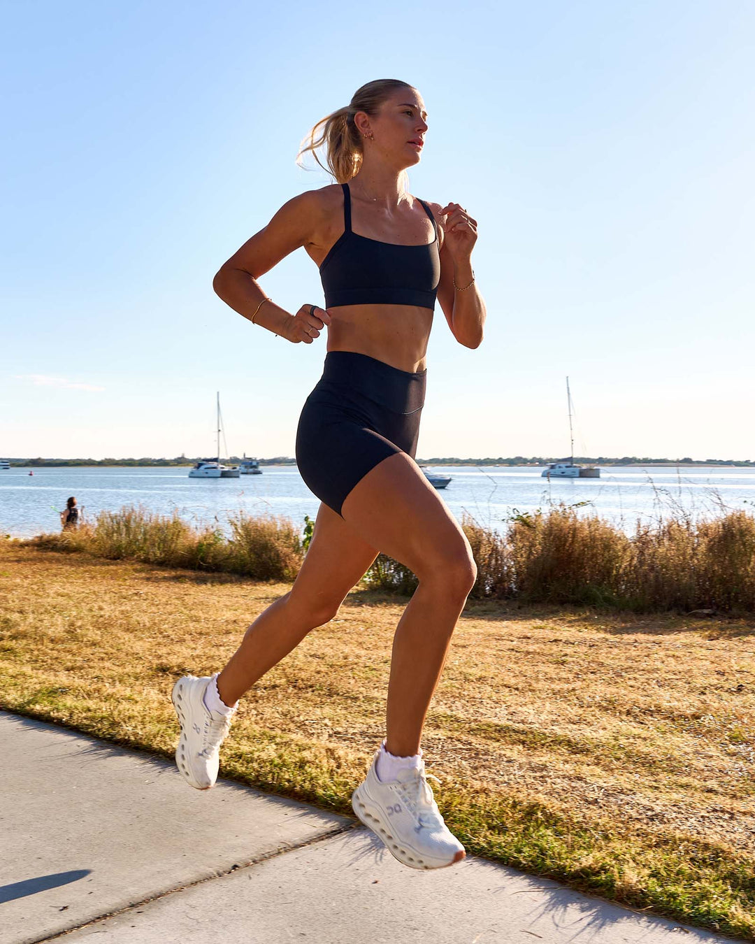 Woman wearing Elite Run High-Rise 5" Short Pockets - Black | Model:Emelia | Size:S