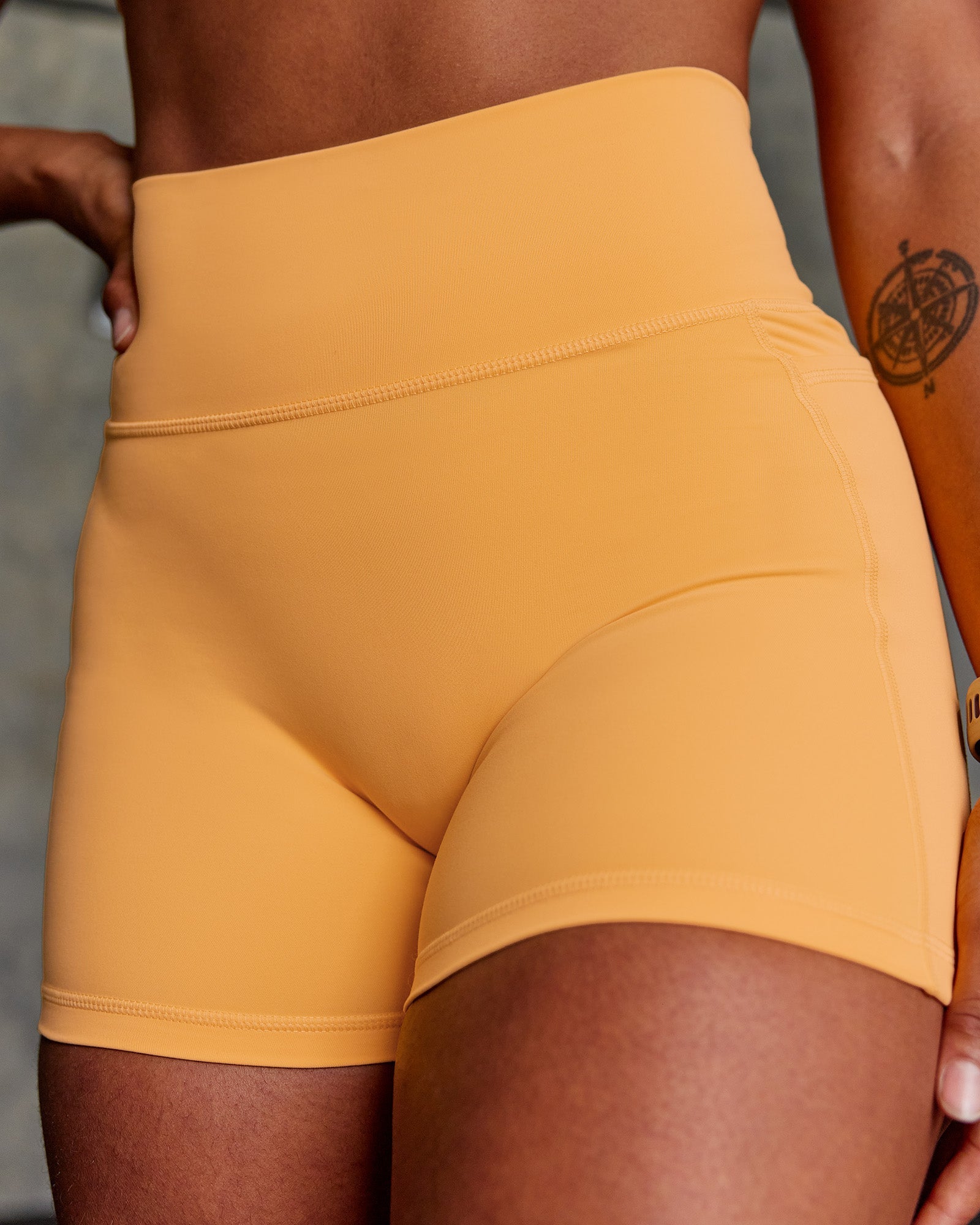 Woman wearing Fusion Ultra High-Rise 4" Short Pockets - Warm Apricot | Model:Janet | Size:S