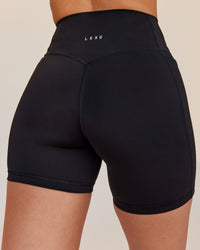 Woman wearing Fusion V-Contour Ultra High-Rise 6" Short Pockets - Black | Model:Rhiley | Size:S