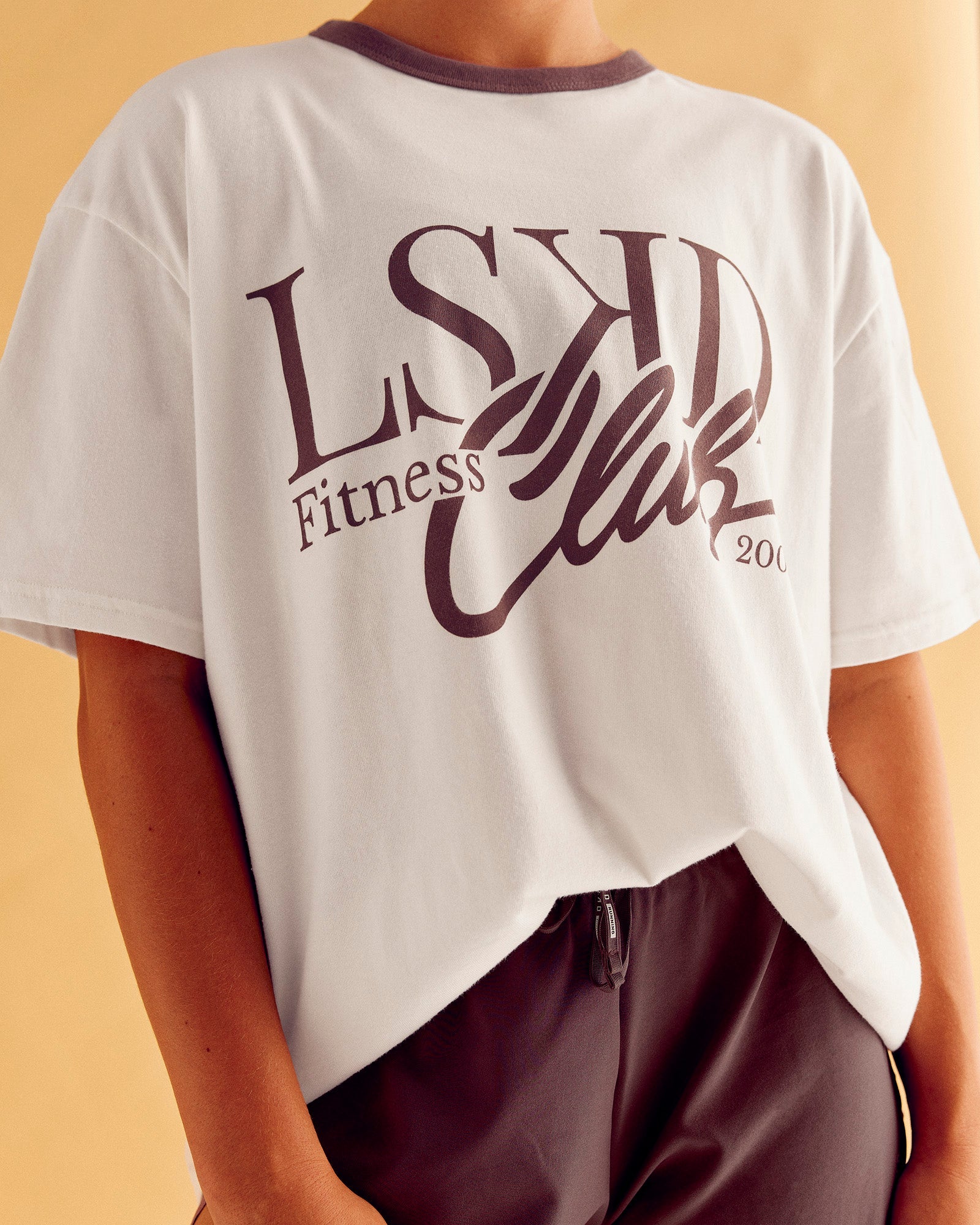 Woman wearing LSKD Fitness Club Heavyweight Oversized Tee - Off White-Cocoa Powder | Model:Charlize | Size:S