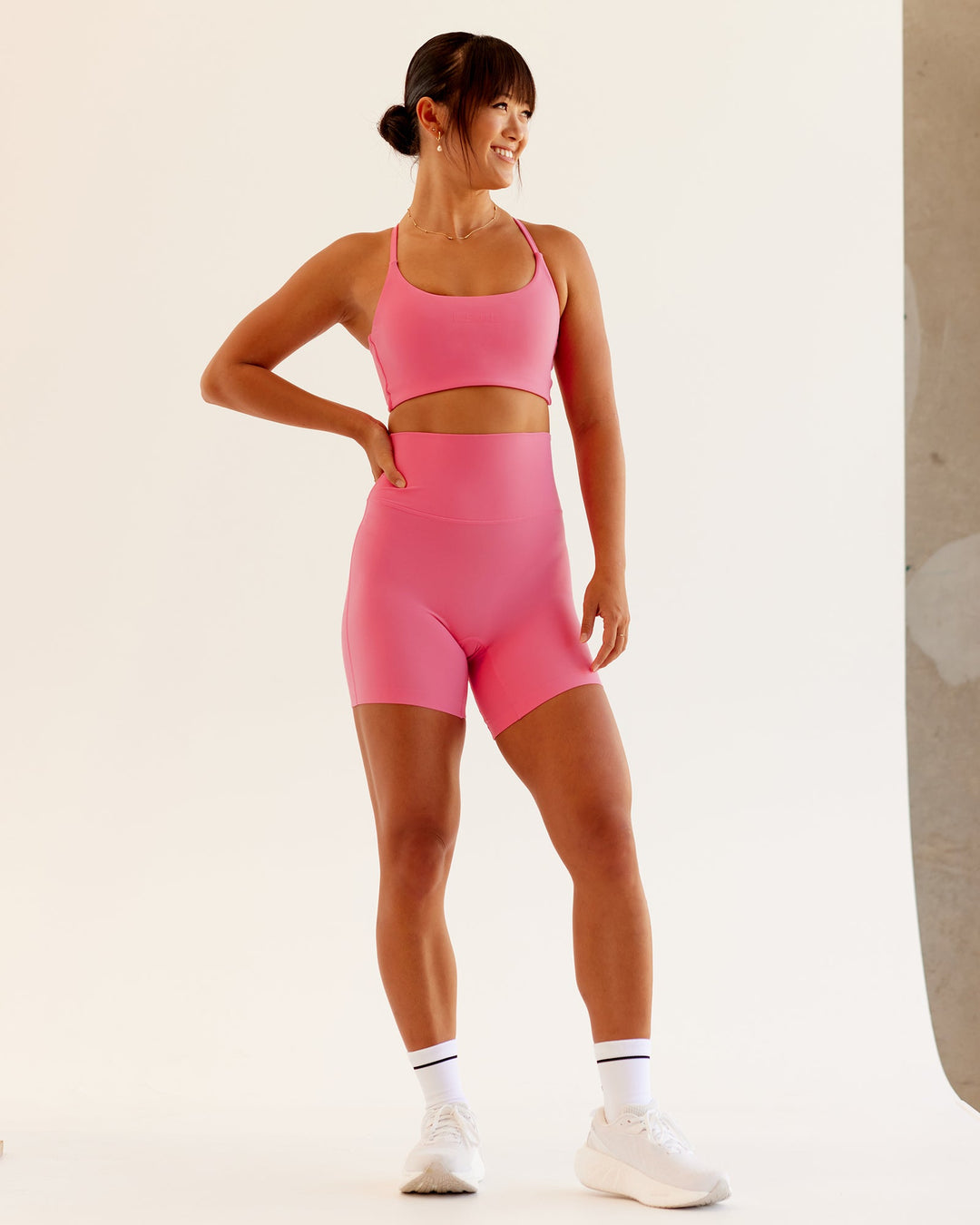 Woman wearing Twist Sports Bra in Pink Lemonade | Size:S