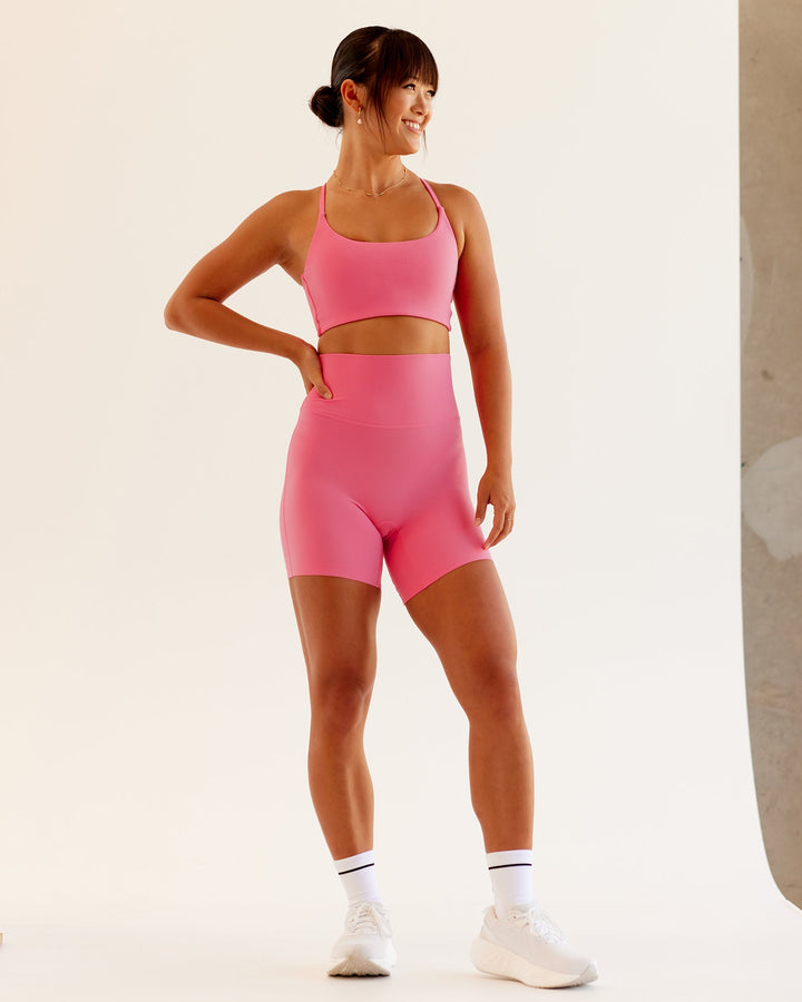 Woman wearing Twist Sports Bra in Pink Lemonade | Size:S
