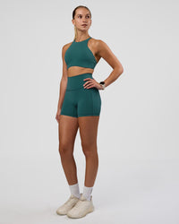 Woman wearing AMRAP High Neck Sports Bra - Transformative Teal | Model:Myrte | Size:S