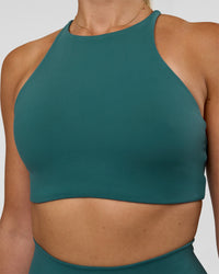 Woman wearing AMRAP High Neck Sports Bra - Transformative Teal | Model:Myrte | Size:S