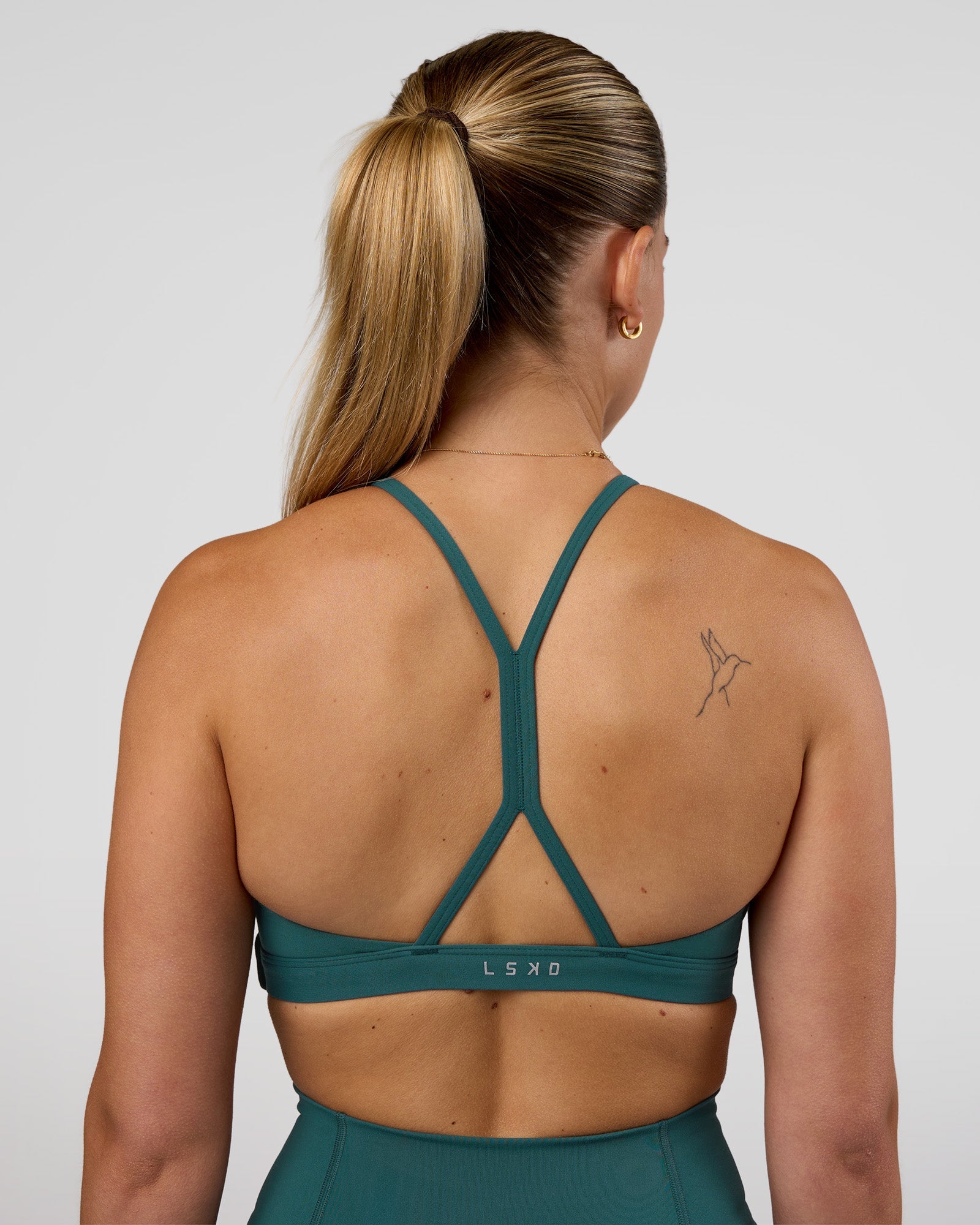 Woman wearing AMRAP High Neck Sports Bra - Transformative Teal | Model:Myrte | Size:S