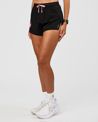 Woman wearing Accelerate 3" High-Rise Running Short - Black-Enjoy The Journey |  Set:true | Angle:side | Model:Rhiley | Size:S