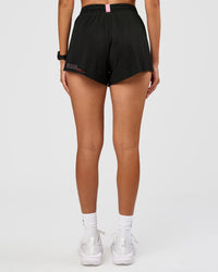 Woman wearing Accelerate 3" High-Rise Running Short - Black-Enjoy The Journey | Set:true | Angle:back | Model:Rhiley | Size:S