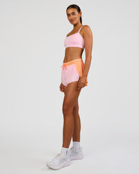 Woman wearing Accelerate 3" Mid-Rise Running Short - Cantaloupe-Marshmallow | Model:Ruby | Size:S